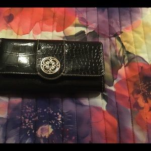 A black faux leather check book wallet